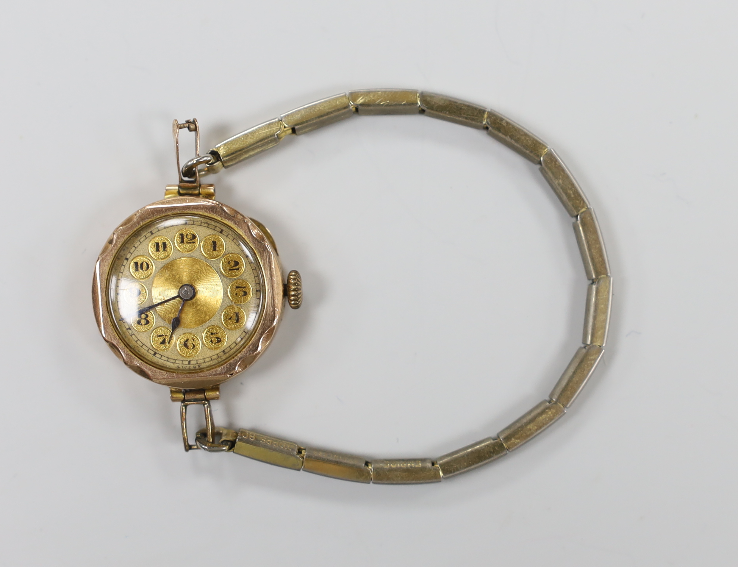 An early 20th century 9ct gold manual wind wrist watch, on a gilt metal flexible strap.